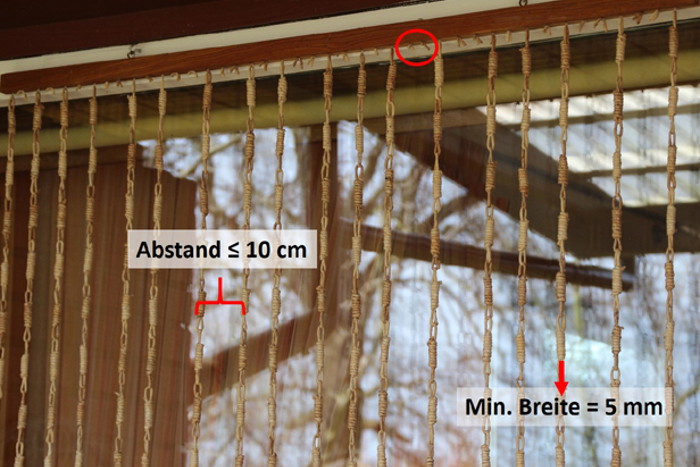 Ein Fliegenvorhang bei dem einzelne Kordeln entfernt wurden. So ist weiterhin die Handflächenregel (=max. 10 cm Abstand zwischen einzelnen Elementen) gegeben. Außerdem sind die Kordeln dick genug (min 5 mm) um als Hindernis wahrgenommen zu werden.